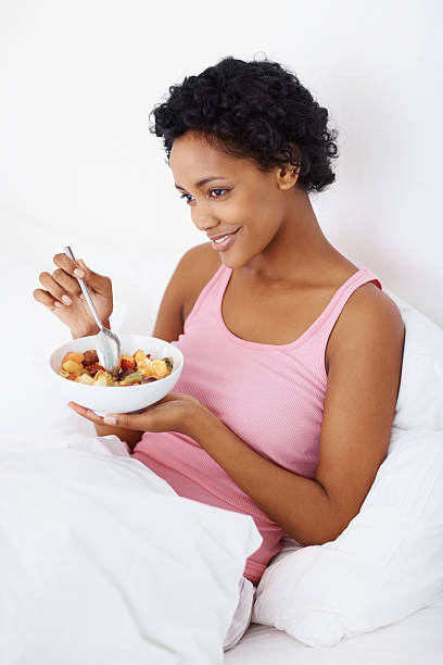 istock Happy thoughtful female eating breakfast in bed 182797277