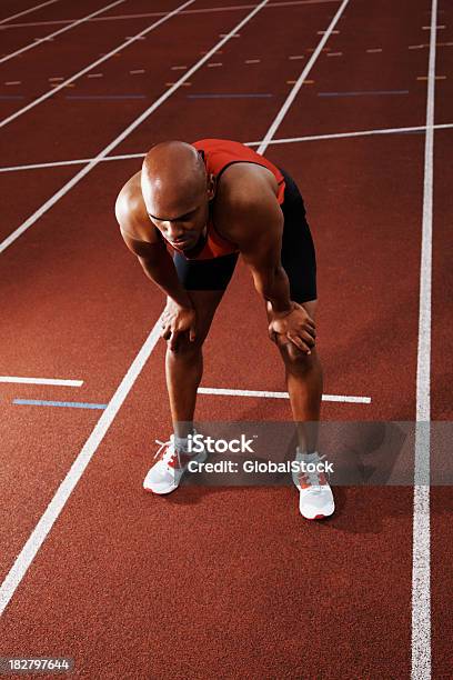 Tired Athlete Bending On Running Track Stock Photo - Download Image Now - Defeat, Exhaustion, Loss