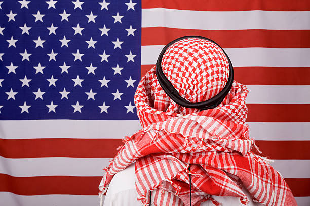 Man with keffiyah before American Flag
