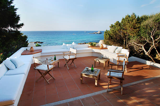 Seaside terracotta terrace surrounded by trees, sea on background