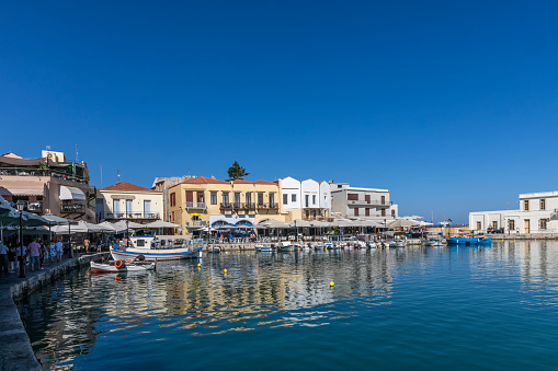 Rethymno, Greece - September 23. 2019. Venetian Harbour with small fishing boats and waterfront restaurants in Rethymno, Crete