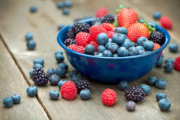 "A bowlful of delicious organic berries.  Strawberries, blackberries, blueberries and raspberries.  Shallow dof"