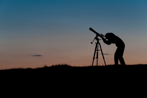 Female amateur astronomer observing the night sky using a three inch refracting telescope on an equatorial mount. More astronomy themes in this lightbox::