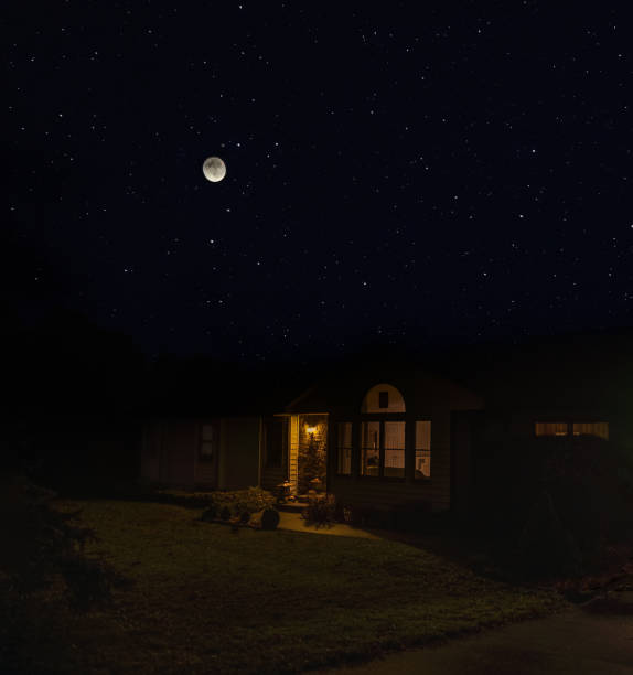 istock View of Midwestern house with lit  windows on starry night with full moon 1828010093