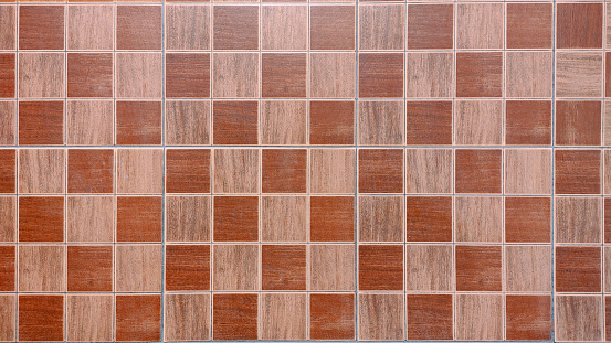 Monochrome brown checkered pattern background of multi colored tiles, front view