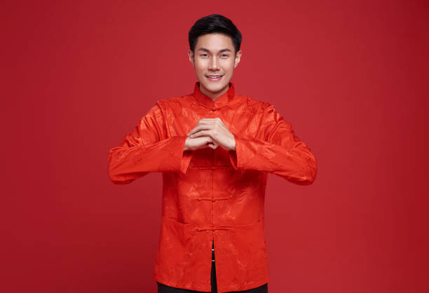 Happy Chinese new year. Asian man wearing red clothing with gesture of congratulation isolated on red background. Happy Chinese new year. Asian man wearing red clothing with gesture of congratulation isolated on red background. 2024 30 stock pictures, royalty-free photos & images