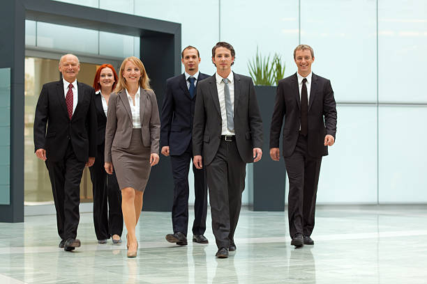 istock staff walking in office hall, close 182801203
