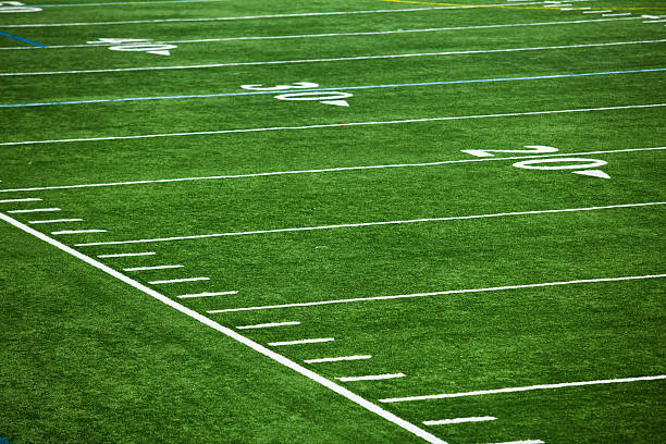 Football field with defocused scoreboard in the background.