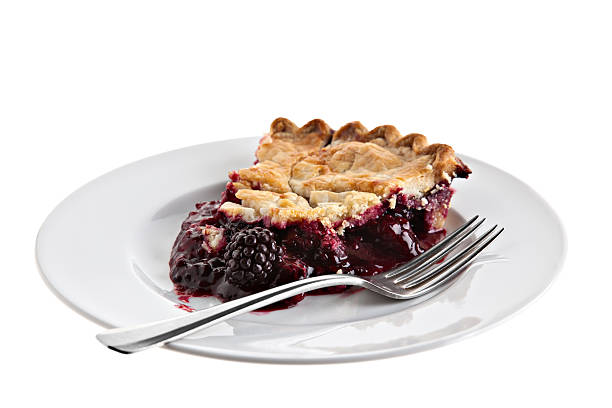 Blackberry Pie Slice A blackberry pie slice on a white plate with a fork on a white background. marionberry stock pictures, royalty-free photos & images