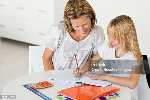 Madre Ayudando A Su Hija Con La Tarea Foto de stock y más banco de imágenes de Adulto - Adulto, Alegre, Aprender