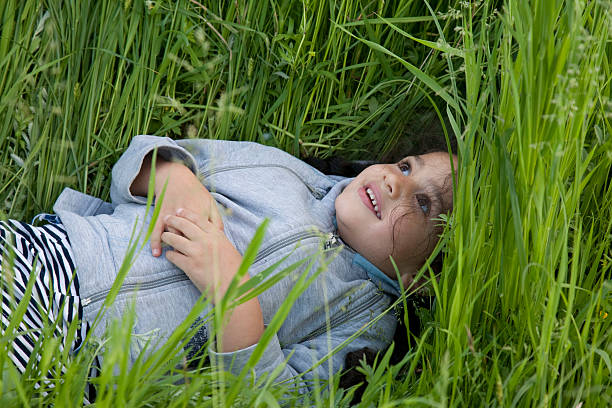 istock Little girl ying on the grass. 182802280