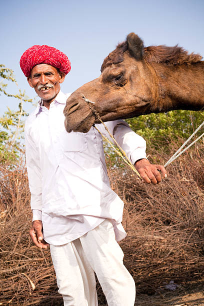 istock Traditional Rural Indian Man with his Camel in Rajasthan 182802651