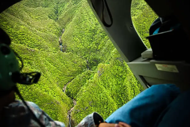 "Helicopter ride with open doors over Sacred Falls State Park on Oahu, Hawaii."