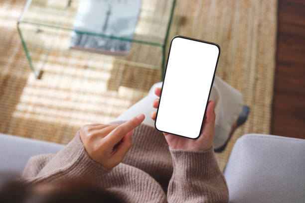 istock Top view mockup image of a woman holding mobile phone with blank desktop white screen 1828028828