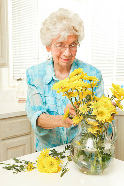 istock senior woman arranging flowers 182804449