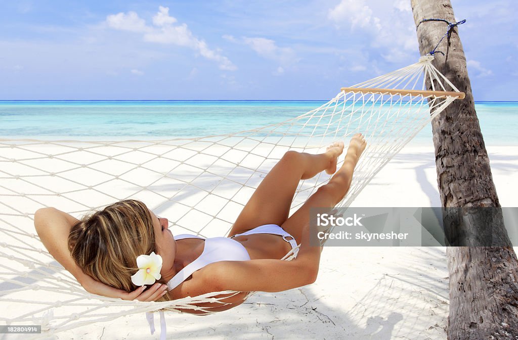 Vista traseira da mulher relaxando em uma rede. - Foto de stock de Deitar royalty-free