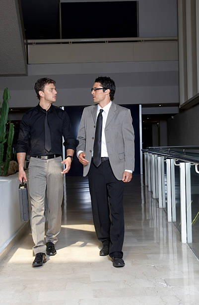 istock Two young businessman walking and talking 182805375