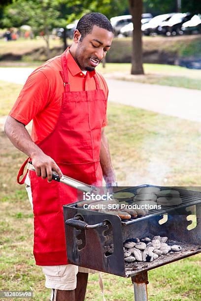 Foto de Afroamericano Homem De Churrasco Hambúrgueres Cachorrosquentes E Salsichas e mais fotos de stock de Grelhado - Cozido