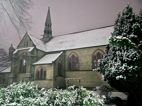 Snow covered church at night, eerie and magical and cold.