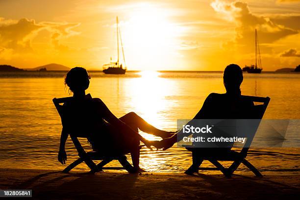 Photo libre de droit de Couple Sur La Plage En Regardant Le Coucher De Soleil Dans Les Caraïbes banque d'images et plus d'images libres de droit de Caraïbes