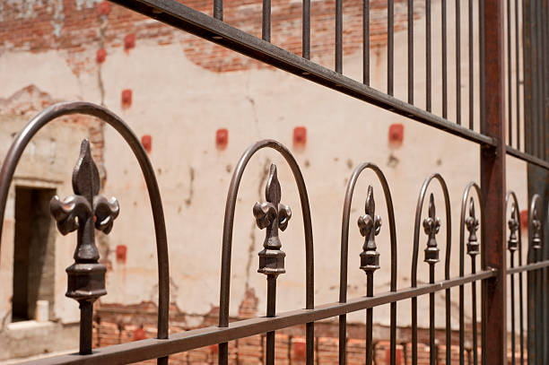 Fleur De Lys Gate Iron Fleur De Lys gate blocking access to old structure new orleans fleur de lis stock pictures, royalty-free photos & images
