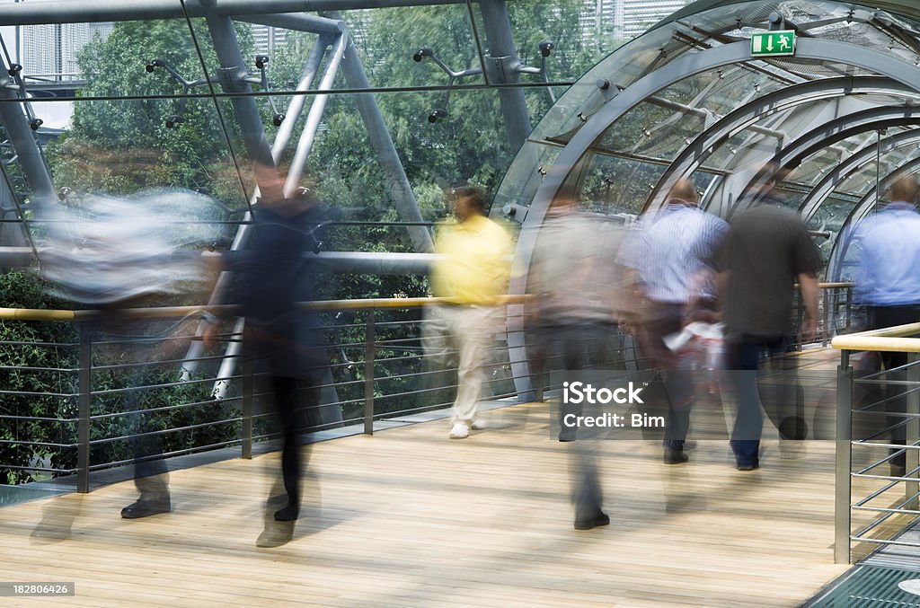 Marche à pied par une passerelle au bâtiment moderne en verre, Mouvement flou - Photo de Panneau d'entrée libre de droits