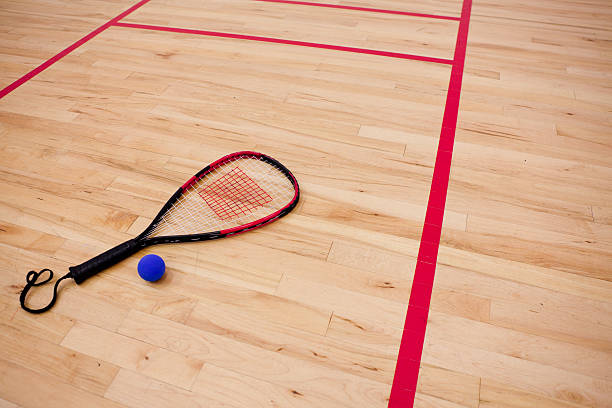 Racquet equipment on court Racketball equipment sitting on wood court with red lines and blue ball. racketball stock pictures, royalty-free photos & images