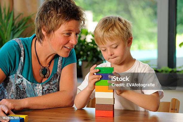 Teacher And Pupil Building Colored Blocks Stock Photo - Download Image Now - Down Syndrome, Adult, Teacher