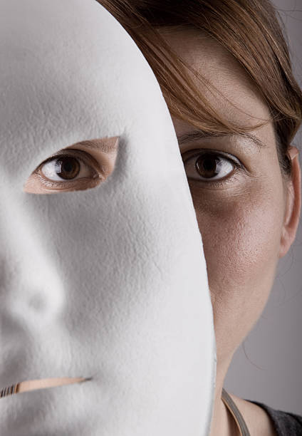 Senior woman with carnival mask on her face isolated on white studio background