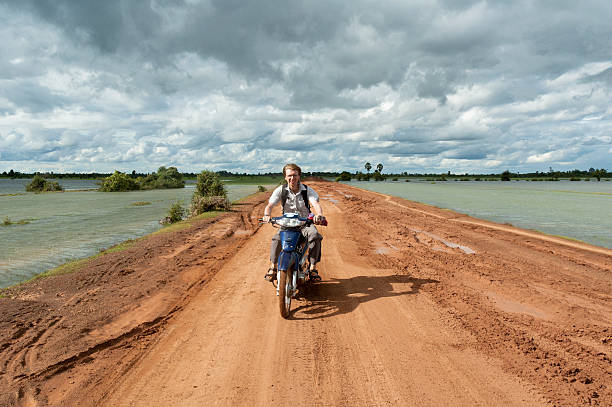 motorcycling no camboja - flood people asia cambodia - fotografias e filmes do acervo