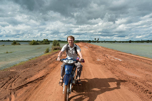 motorcycling no camboja - flood people asia cambodia - fotografias e filmes do acervo