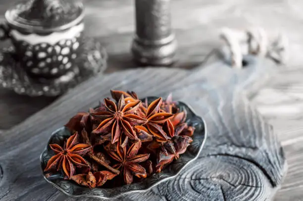 Fresh organic fruits and spice seeds from star anise . Still life in Arabic style. Organic dry star anise. aniseed stars on a dark rustic background.