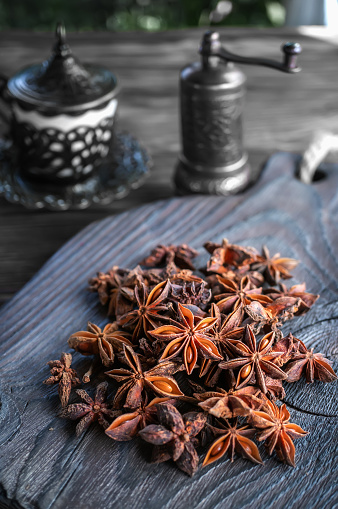 Fresh organic fruits and spice seeds from star anise with a spice grinder. Organic dry star anise. aniseed stars on a dark rustic background.