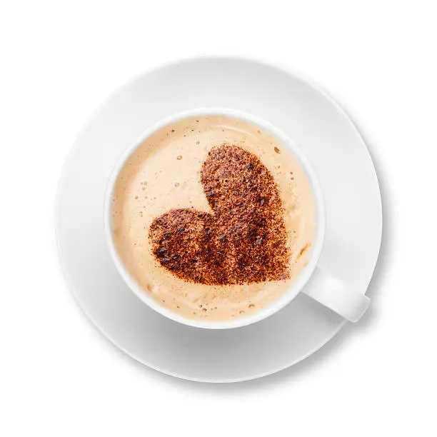 Photo of Cappuccino in white cup and saucer with chocolate heart