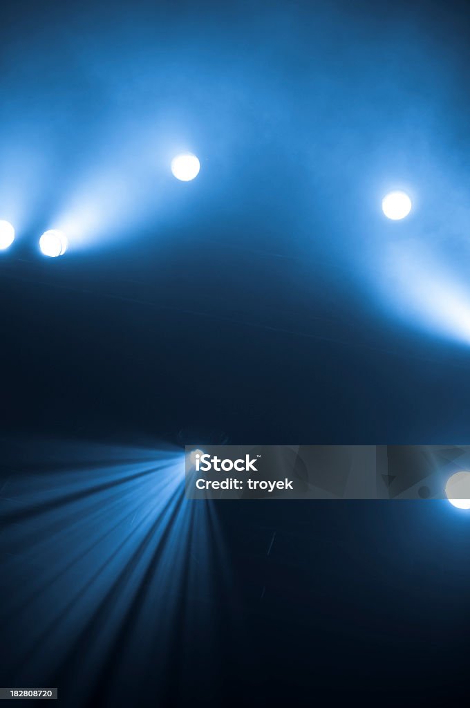 Bright spotlights shining on stage with blue and black hues Stage Lights, concert Abstract Stock Photo