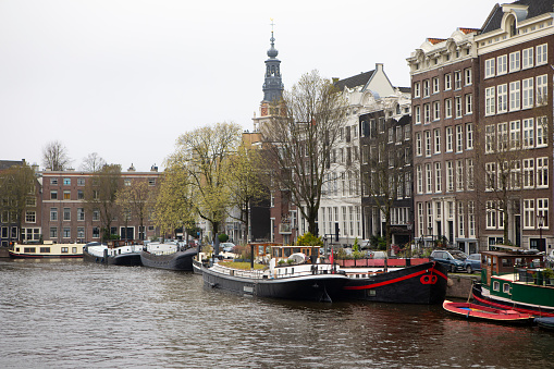 Amsterdam skyline with moored boats, townhouses and Zuiderkerk