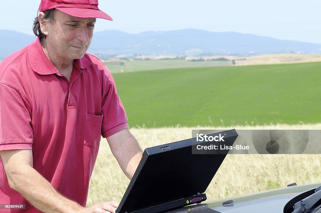 Busy фермер, работает на ноутбуке - Стоковые фото 40-44 года роялти-фри