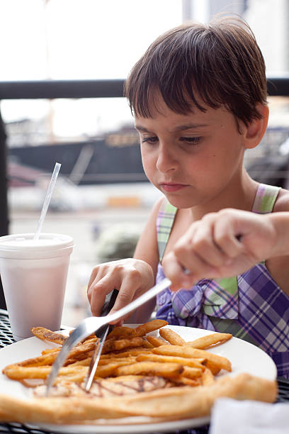 istock little girl eating in open-air cafe 182809443