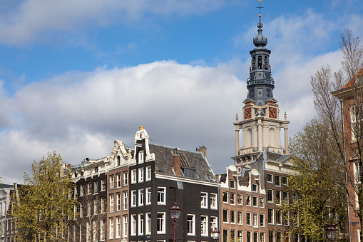 CLOSE UP: Gorgeous 17th century slim and high canal houses along Amsterdam waterway opened as museums, offices and hotels. Famous buildings with historic facades, skinny profile and grand gables