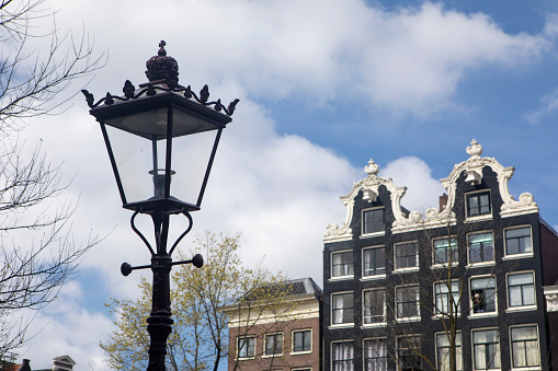 Delft, The Netherlands - October 10, 2019: A fragment of the front facade of the historic church illuminated by sunlight shows the beauty of brick architecture. Delft is a popular tourist destination. Many tourists come here and find in this city a summary of the architecture, art and landscape of the Netherlands. Many historical buildings have been preserved in the old part of the city. There are many narrow streets and many of them are canals, the banks of which are connected by small bridges. The city is known for its connections to art, culture and science.