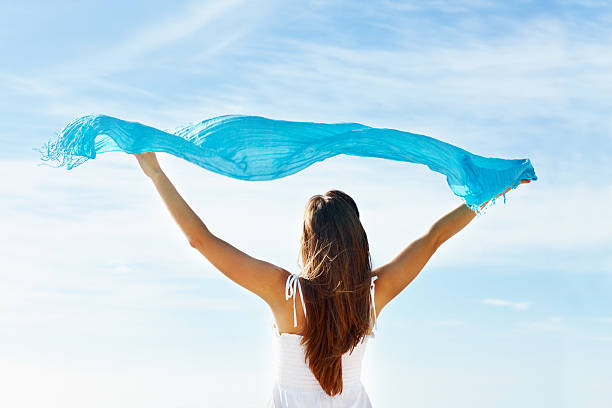 istock Woman holding up sarong aganist sky 182810636