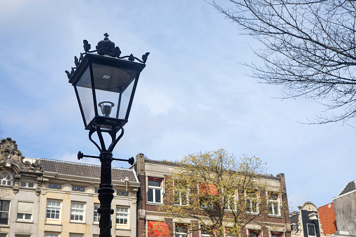 Antique stylish street lamp at blue sky background. Decorative retro vintage lantern on wrought iron lamp post for image design. Street art concept. Copy text space for advertising