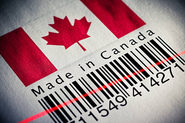 Made in Canada product's barcode Close up of a barcode with Canadian flag.Grazing light emphasise the paper texture and grain. canadian culture canada business bar code stock pictures, royalty-free photos & images