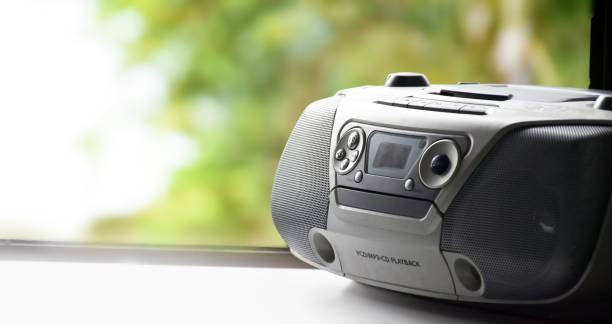 Cassette and CD player in 1990 style Cassette and CD player in 1990 style on window with natural blurred background. 1990’s vintage life style concept. open cd player stock pictures, royalty-free photos & images