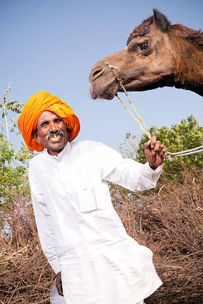istock Traditional Rural Indian Man with his Camel in Rajasthan 182811196