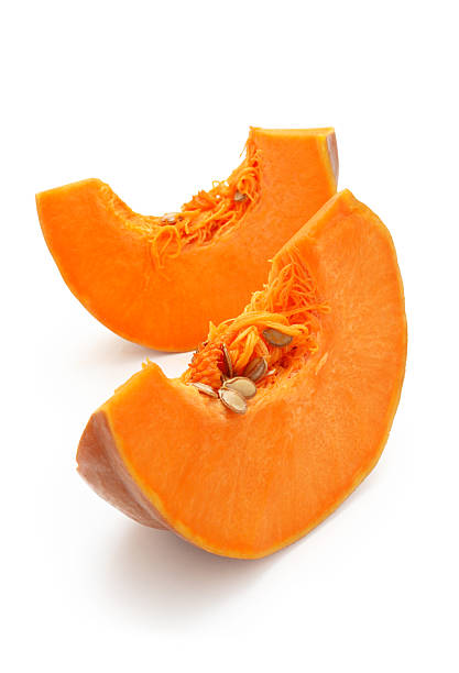 Two slices of pumpkin with the seeds still in stock photo