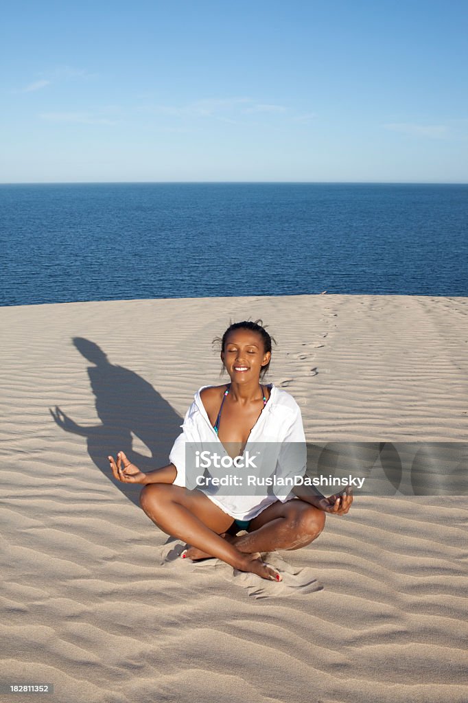 Attractive woman in yoga position on the beach. Attractive woman in yoga position sitting on the beach. Adult Stock Photo