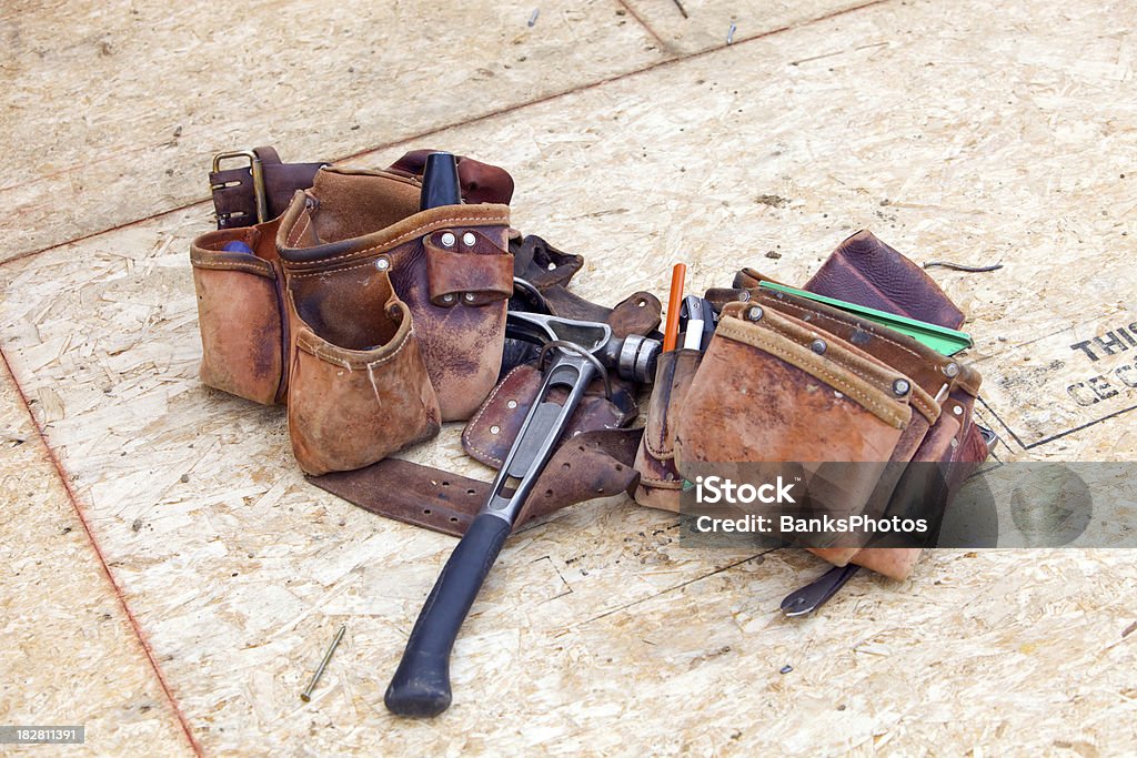 Construction Worker’s Leather Tool Belt at rest on OSB Floor  Tool Belt Stock Photo