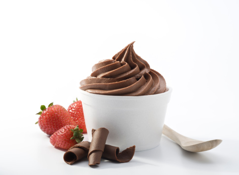 SEVERAL MORE IN THIS SERIES. Cup of frozen soft-serve chocolate yogurt with fresh strawberries and chocolate curls and eco-friendly bamboo spoon.  XXXL high resolution shot.