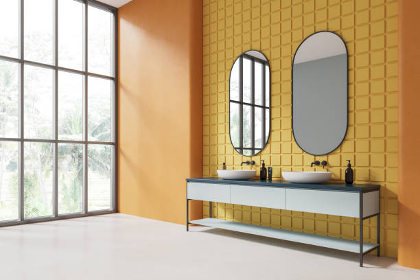 istock Orange and yellow tiled bathroom corner with double sink 1828118636